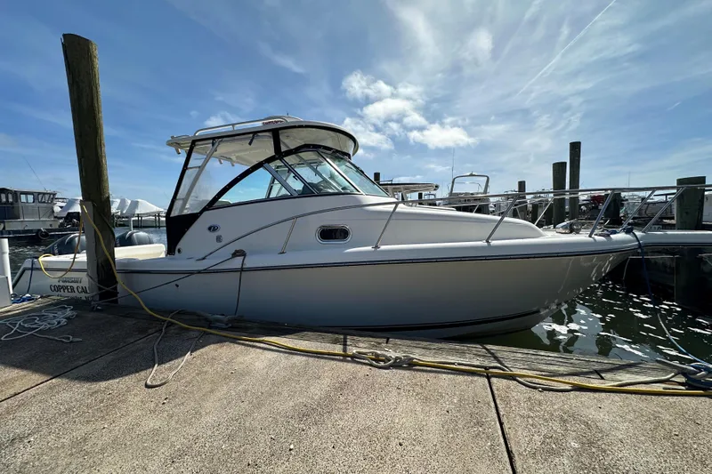 Slide: The Image of 2007 Pursuit OS 285 Offshore boat docked at marina under clear blue sky. - 21
