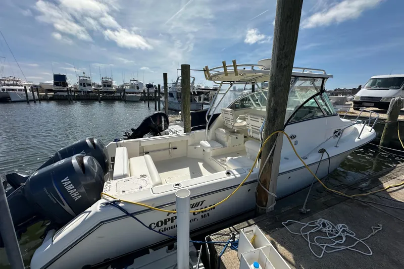 Slide: The Image of 2007 Pursuit OS 285 Offshore boat docked with Yamaha engines, sunny marina background. - 22