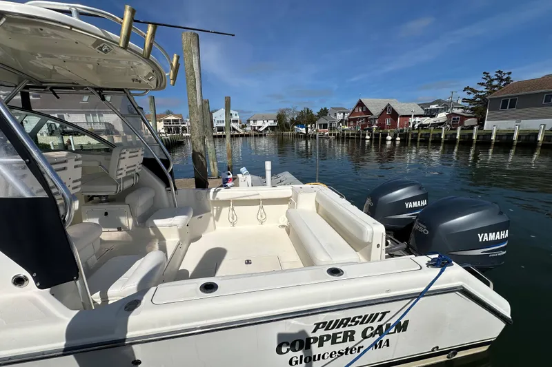 Slide: The Image of 2007 Pursuit OS 285 Offshore boat docked, featuring Yamaha engines, in a scenic harbor setting. - 4