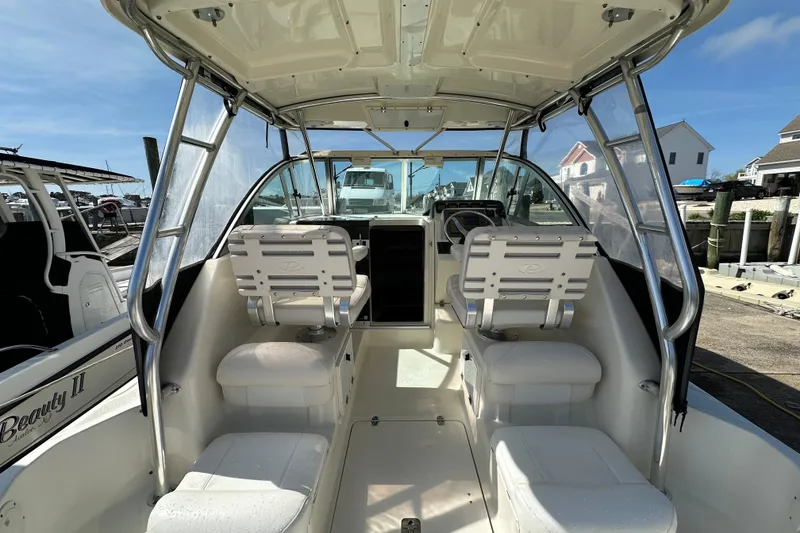 Slide: The Image of 2007 Pursuit OS 285 Offshore boat interior with helm and seating, docked at marina. - 8