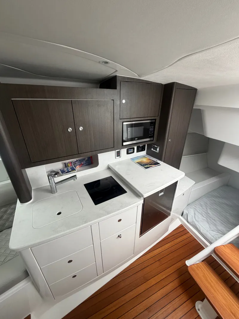 Slide: The Image of 2024 Intrepid Valor yacht interior with modern kitchen and wooden flooring. - 15