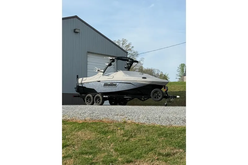 Slide: The Image of 2023 Malibu Wakesetter 23 LSV boat on trailer near a building. - 10
