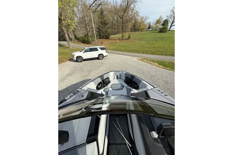 Slide: The Image of 2023 Malibu Wakesetter 23 LSV boat parked on gravel driveway with SUV nearby. - 8