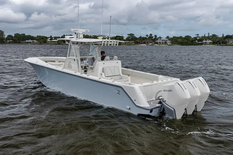 Slide: The Image of 2022 SeaVee 370Z boat with triple Mercury engines on a calm waterway. - 10