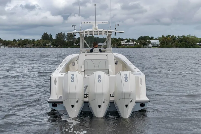 Slide: The Image of 2022 SeaVee 370Z boat with triple outboard engines on a calm waterway. - 12