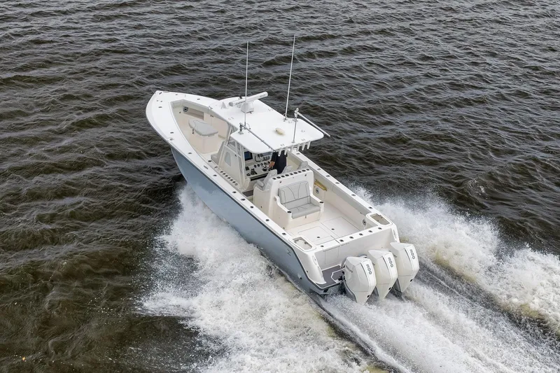 Slide: The Image of 2022 SeaVee 370Z boat cruising on open water with triple outboard engines. - 26