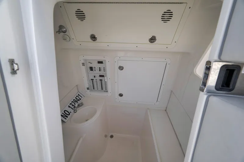 Slide: The Image of Interior of 2022 SeaVee 370Z boat, featuring a compact bathroom with control panel. - 36