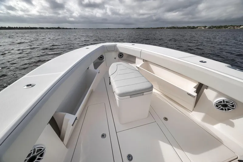 Slide: The Image of 2022 SeaVee 370Z boat interior with seating and storage, on a calm water body. - 41