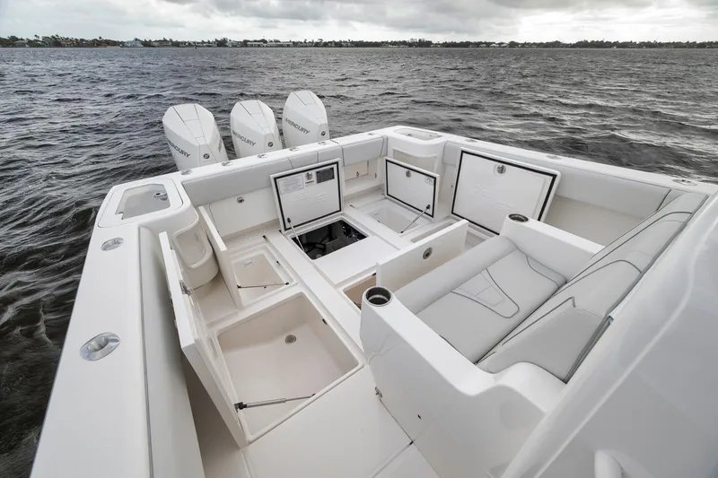 Slide: The Image of 2022 SeaVee 370Z boat with open storage compartments and triple Mercury engines on the water. - 55
