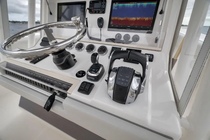 Slide: The Image of Control panel of a 2022 SeaVee 370Z boat with steering wheel and navigation equipment. - 65