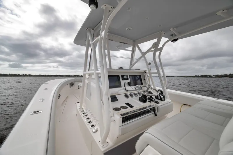 Slide: The Image of 2022 SeaVee 370Z boat interior with helm, steering wheel, and navigation screens on open water. - 66