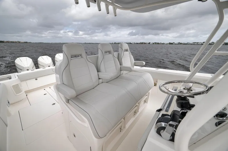Slide: The Image of 2022 SeaVee 370Z boat interior with luxurious seating and steering wheel, overlooking the water. - 67