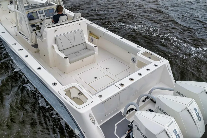 Slide: The Image of 2022 SeaVee 370Z boat with spacious deck and triple Mercury engines on water. - 7