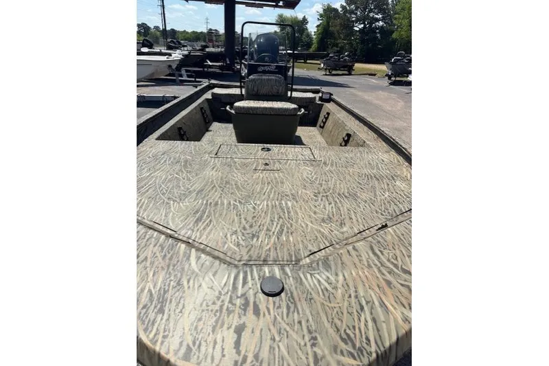 Slide: The Image of 2026 Tracker Grizzly 1860 CC boat with camouflage pattern, parked outdoors. - 6