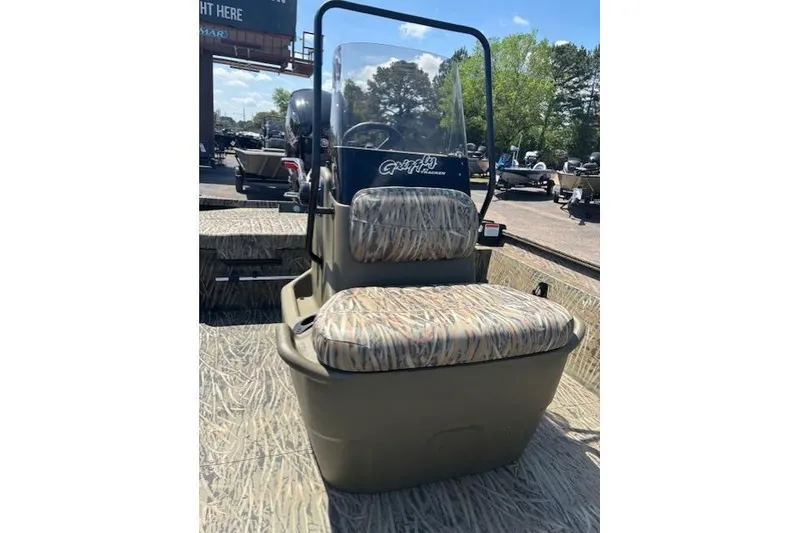 Slide: The Image of 2026 Tracker Grizzly 1860 CC boat with camouflage seating and console, outdoors. - 7