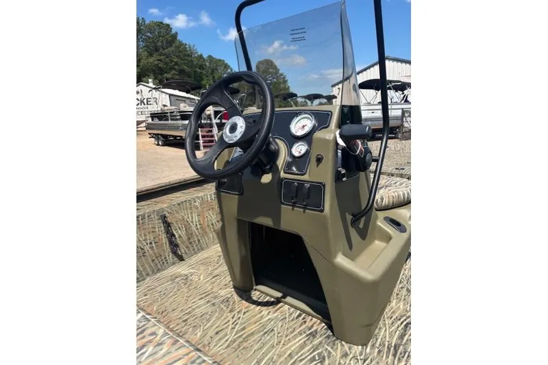 Slide: The Image of 2026 Tracker Grizzly 1860 CC boat console with steering wheel and gauges, outdoors. - 9