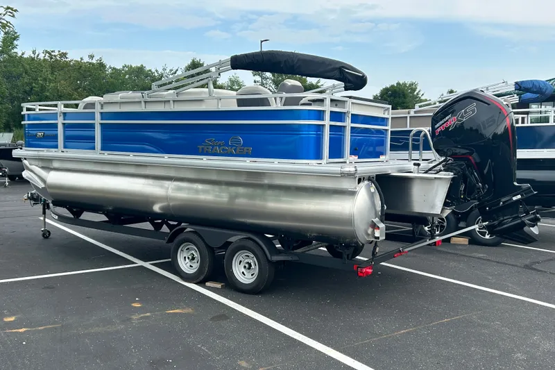 Slide: The Image of 2026 Sun Tracker Fishin' Barge 20 DLX pontoon boat on trailer in parking lot. - 113