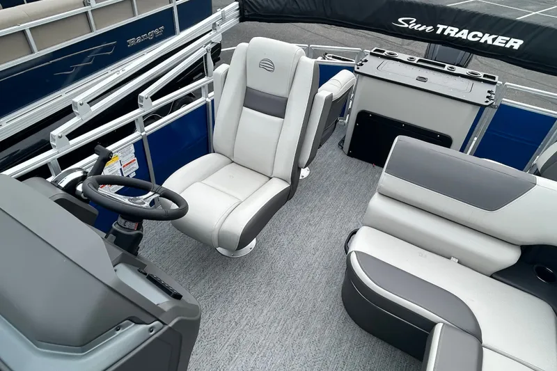 Slide: The Image of 2026 Sun Tracker Fishin' Barge 20 DLX interior with seating and steering wheel. - 12
