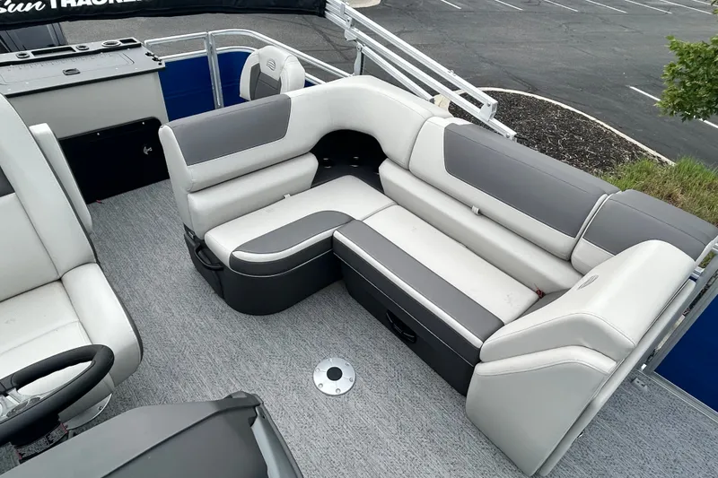 Slide: The Image of 2026 Sun Tracker Fishin' Barge 20 DLX interior with gray seating and carpeted floor. - 13