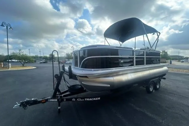 Slide: The Image of 2026 Sun Tracker Party Barge 20 DLX pontoon boat on trailer under cloudy sky. - 2