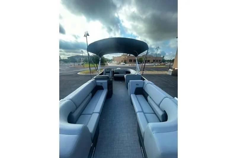 Slide: The Image of 2026 Sun Tracker Party Barge 20 DLX with spacious seating and canopy, parked outdoors. - 4