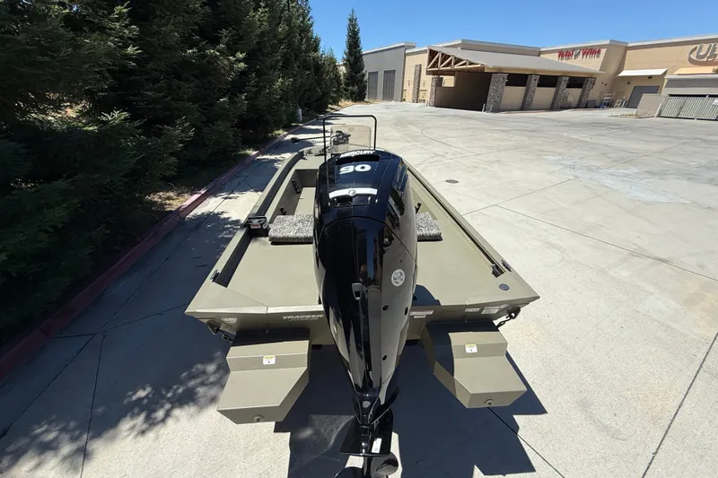 Slide: The Image of 2026 Tracker Grizzly 1860 CC boat with Mercury 90 engine in a parking lot. - 5
