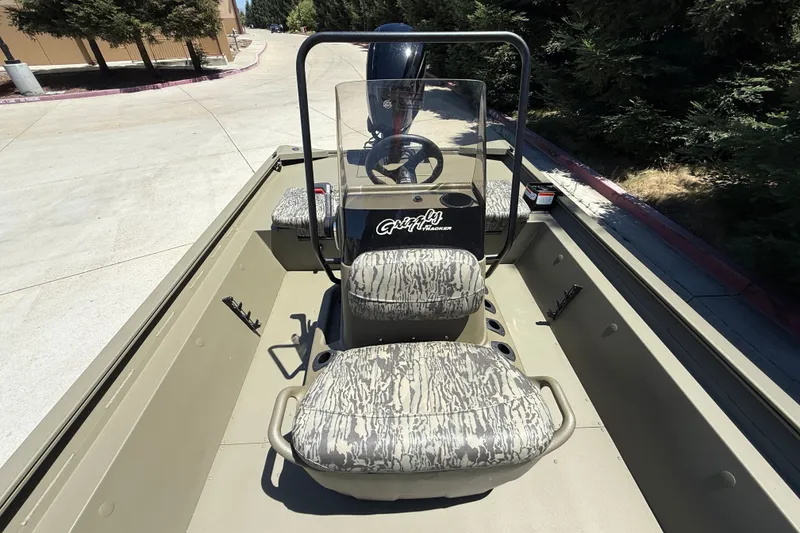 Slide: The Image of 2026 Tracker Grizzly 1860 CC boat interior with camouflage seating and steering console. - 22
