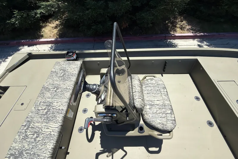 Slide: The Image of 2026 Tracker Grizzly 1860 CC boat interior with camouflage seating and steering console. - 23