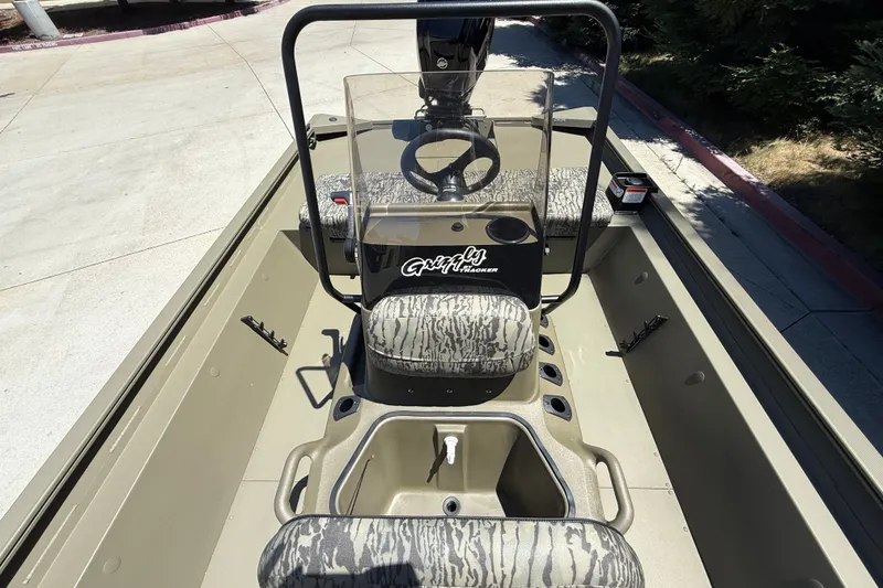 Slide: The Image of 2026 Tracker Grizzly 1860 CC boat interior with camouflage seating and steering console. - 21