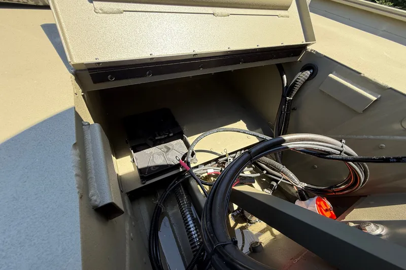 Slide: The Image of Open compartment of 2026 Tracker Grizzly 1860 CC boat showing wiring and components. - 19