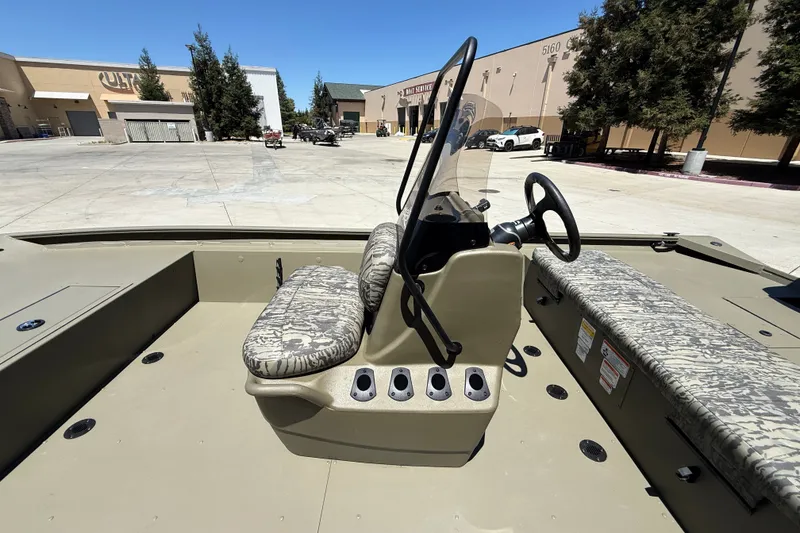 Slide: The Image of 2026 Tracker Grizzly 1860 CC boat interior with camouflage seating and steering console. - 17