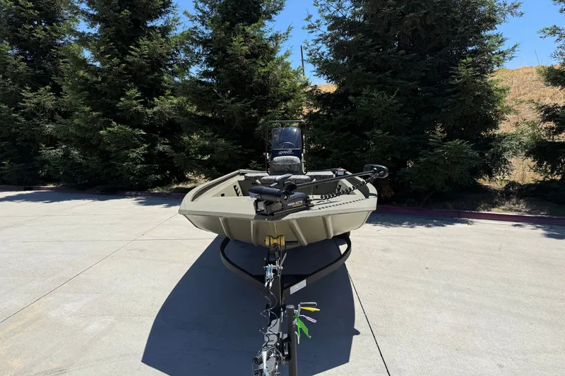 Slide: The Image of 2026 Tracker Grizzly 1860 CC boat on trailer, parked outdoors near trees. - 4