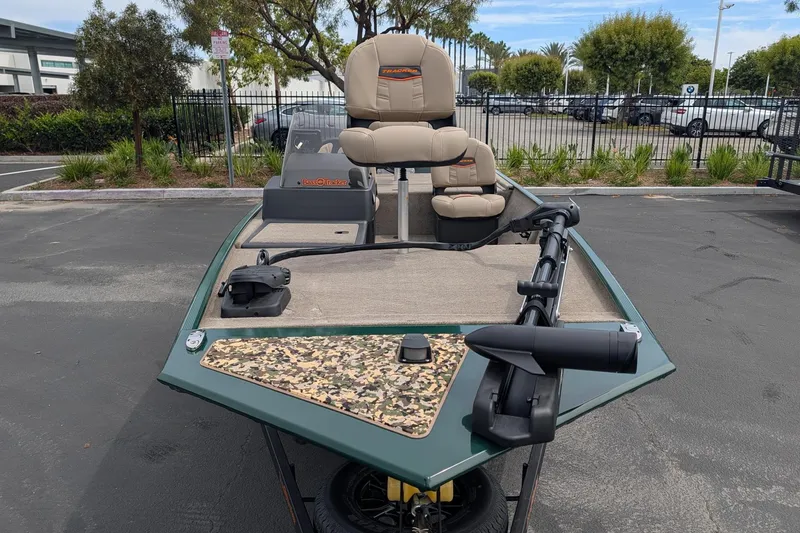 Slide: The Image of 2026 Tracker Bass Tracker Classic Limited boat in parking lot, featuring beige seats and trolling motor. - 2