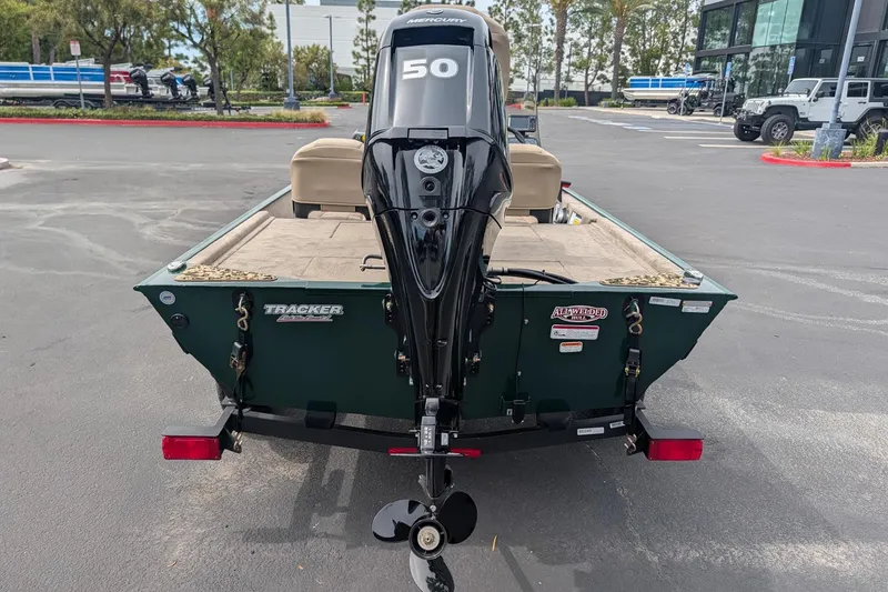 Slide: The Image of 2026 Tracker Bass Tracker Classic Limited boat with powerful outboard motor in parking lot. - 4