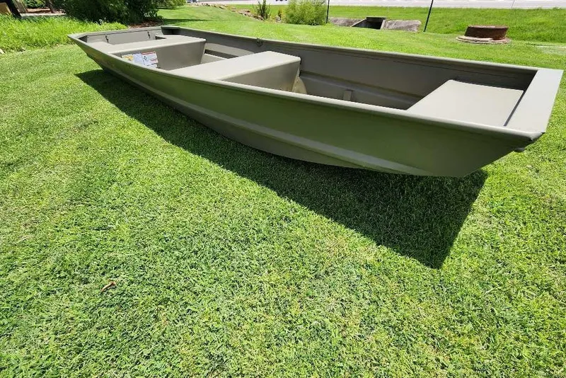 Slide: The Image of 2026 Tracker Grizzly 14 Jon boat on green grass, showcasing its sturdy design. - 5