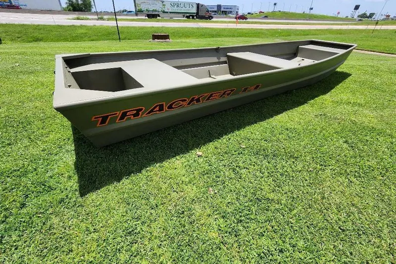 The Image of 2026 Tracker Grizzly 14 Jon boat on grass, showcasing its sturdy design and spacious interior. - 0