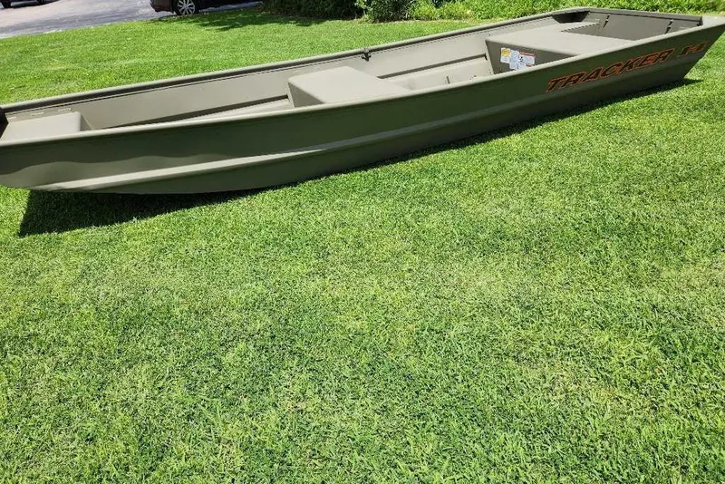 Slide: The Image of 2026 Tracker Grizzly 14 Jon boat on green grass, side view. - 2