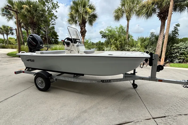 The Image of 2026 Mako Pro Skiff 13 CC boat on trailer, surrounded by palm trees. - 0
