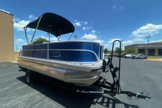 Slide: The Image of 2026 Sun Tracker Party Barge 18 DLX pontoon boat on trailer, parked outdoors. - 2