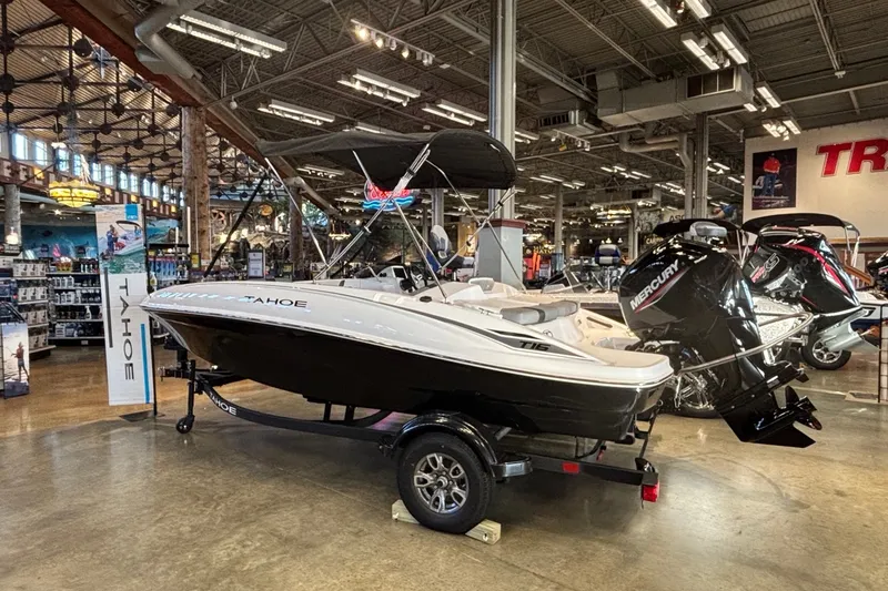Slide: The Image of 2026 Tahoe T16 boat displayed in a showroom with Mercury outboard motor. - 2