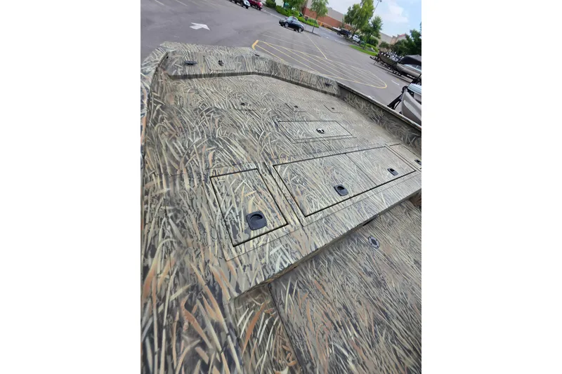 Slide: The Image of 2026 Tracker Grizzly 2072 CC boat with camouflage deck in a parking lot. - 5