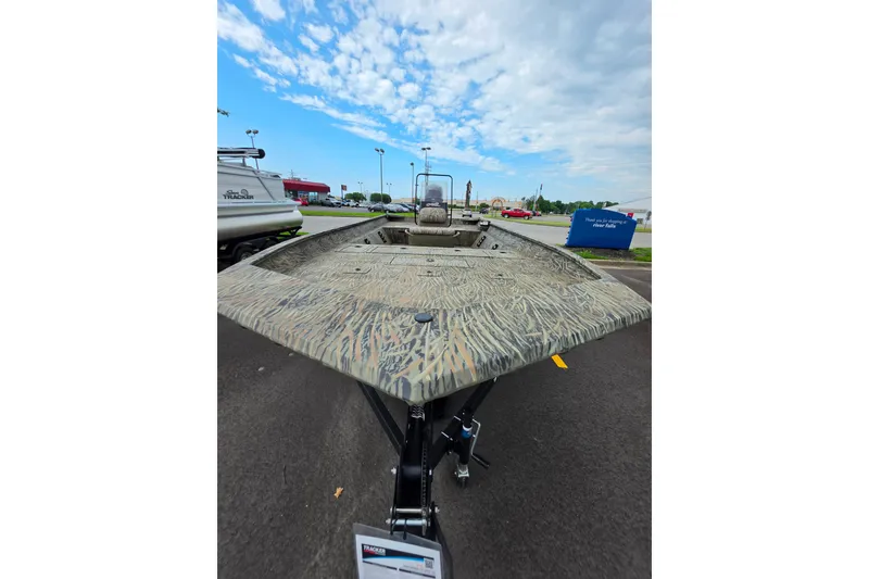 Slide: The Image of 2026 Tracker Grizzly 2072 CC boat with camouflage design on display outdoors. - 6