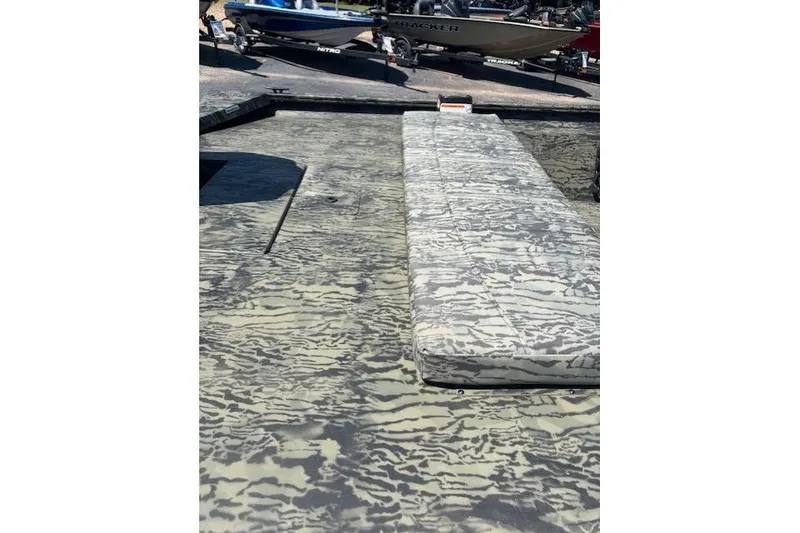 Slide: The Image of 2026 Tracker Grizzly 1860 CC boat with camouflage deck pattern, docked outdoors. - 10