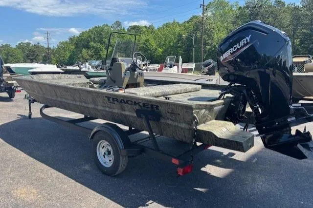 Slide: The Image of 2026 Tracker Grizzly 1860 CC boat with Mercury engine on trailer, parked outdoors. - 2