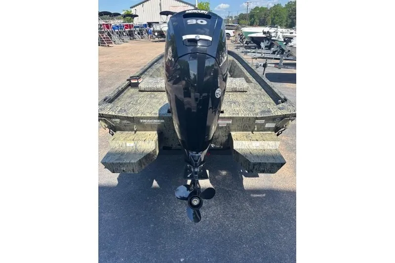 Slide: The Image of 2026 Tracker Grizzly 1860 CC boat with Mercury 90 engine, parked outdoors. - 3
