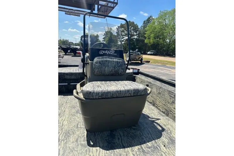 Slide: The Image of 2026 Tracker Grizzly 1860 CC boat with camouflage seating and console, outdoors. - 8