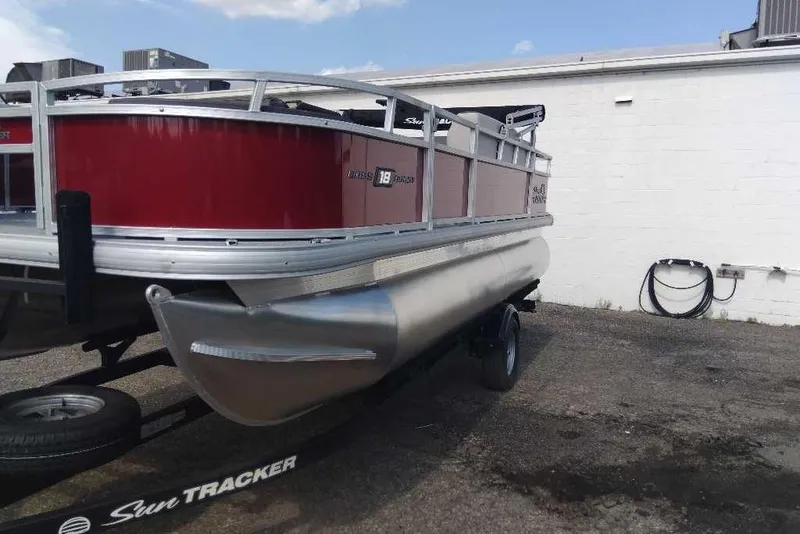 Slide: The Image of 2026 Sun Tracker Bass Buggy 18 DLX pontoon boat on trailer, red and silver design. - 1