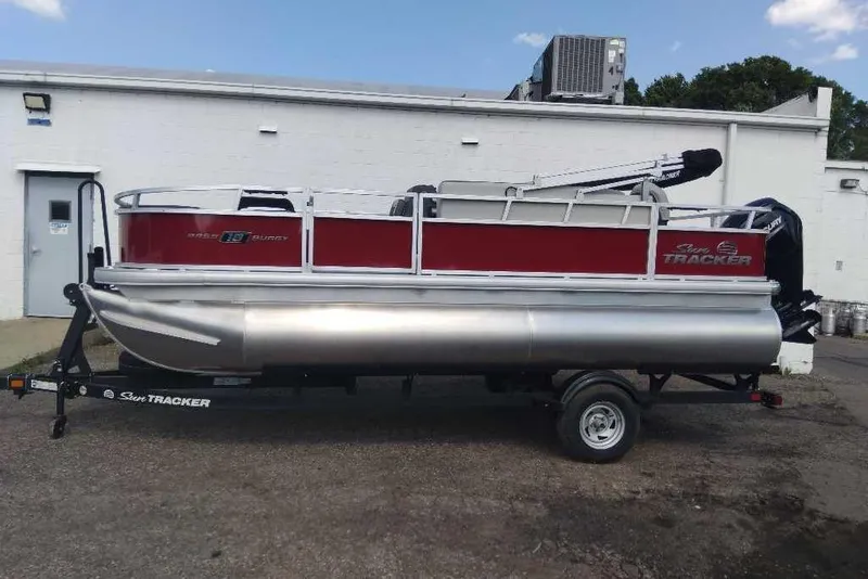 Slide: The Image of 2026 Sun Tracker Bass Buggy 18 DLX pontoon boat on trailer, parked outdoors. - 10