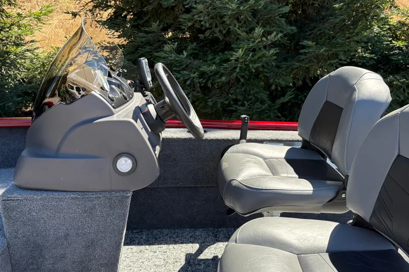 Slide: The Image of 2026 Tracker Super Guide V-16 SC boat interior with steering console and seats. - 19