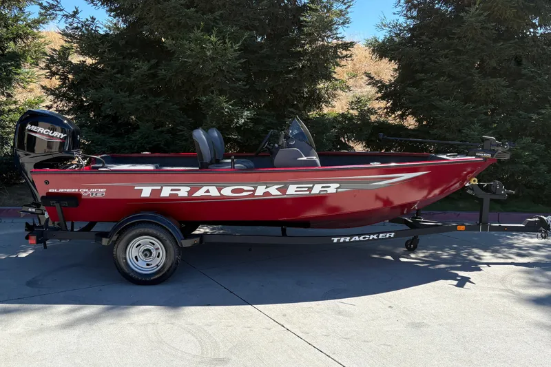 The Image of 2026 Tracker Super Guide V-16 SC boat on trailer, red with Mercury engine. - 0